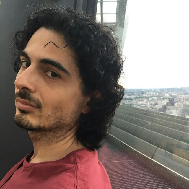 Daniele Giunchi beside a window overlooking a city